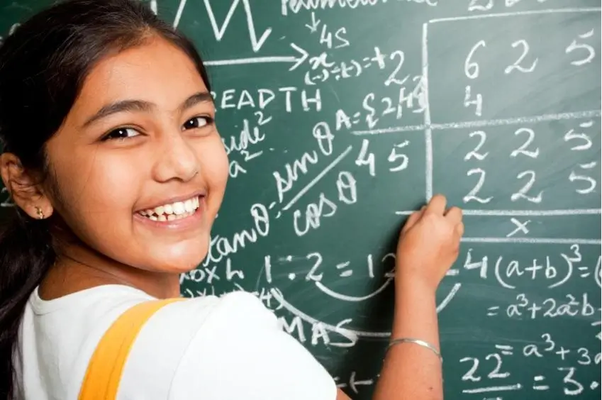 girl student solving problem on board
